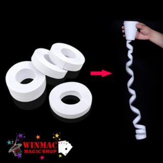 Magician pulling a long white paper coil from a tape cup magic trick